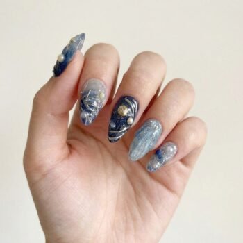 Galaxy Pearl - Handmade navy almond press-on nails with 3D seashells, starfish, and holographic pearls over a shimmering base. | worn on hand 2 | So Does Nails