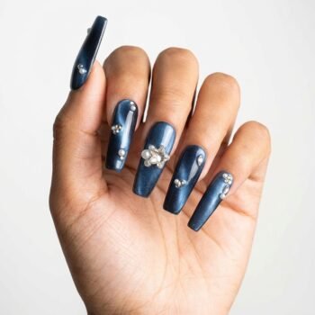 Midnight Star - Handmade long coffin press-on nails with a deep midnight blue shimmer finish, accented with scattered pearls, rhinestones, and a central 3D star-shaped crystal cluster. | worn on hand 2 | So Does Nails