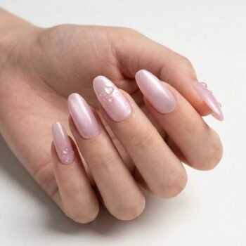 Peachy Paw - Handmade medium almond press-on nails in a soft peachy-pink pearlescent finish, featuring raised 3D water-drop paw print designs. | worn on hand 2 | So Does Nails